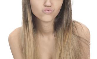 funny female model over white background crosses eyes and makes fish lips funny grimace photo