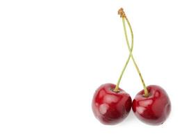 dos cerezas dulces conectadas rojas aisladas en un fondo blanco, fruta sabrosa y madura foto