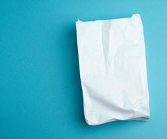 paper disposable food bag on a blue background, concept of delivery and ordering food photo