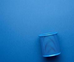 empty iron blue stationery basket for pens and pencils on blue background photo