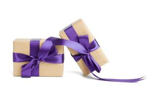 stack of wrapped boxes in brown kraft paper and tied with silk purple ribbon photo