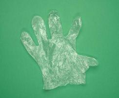 disposable polyethylene glove on a green background photo