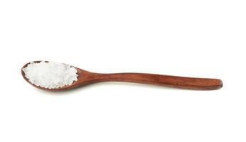 large crystals of white sea salt in a brown wooden spoon photo