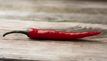 vaina de pimiento rojo sobre una tabla de madera gris foto