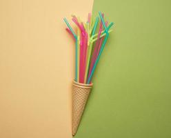 stack of plastic multi-colored cocktail tubes on a green background photo