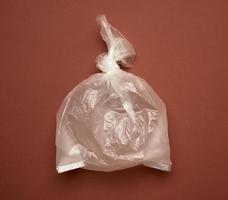 bolsa de plástico transparente en blanco sobre fondo marrón foto