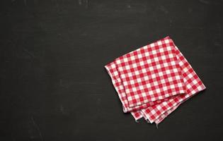 red-white textile kitchen towel on a black wooden background photo