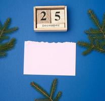 hoja de papel rosa en blanco y calendario de madera con fecha de Navidad 25 de diciembre foto