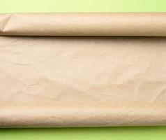 roll of brown parchment paper on a green background, photo