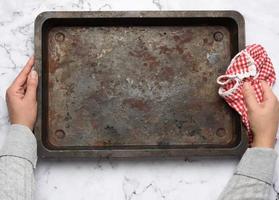 empty metal rectangular baking sheet on a white table, top view photo