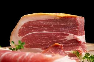 Gran trozo de prosciutto un jamón italiano hecho con jamón rallado con sal foto