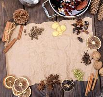 ingredients for making mulled wine on a wooden table and a piece of brown paper photo