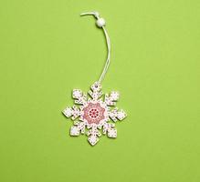 white wooden decorative snowflake on a green background photo