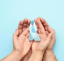 female and male hands holds blue silk ribbon in the shape of a loop photo