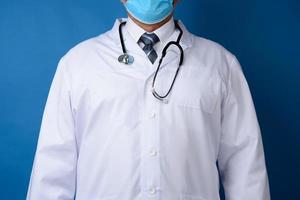 doctor in a white coat stands on a blue background photo