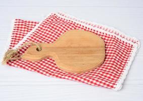 tabla de cortar de cocina de madera marrón y servilleta roja foto