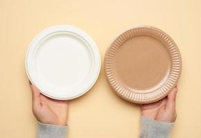 brown and white paper disposable plates on a beige background photo