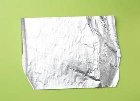 lámina gris para hornear y envasar alimentos sobre un fondo verde, vista superior foto