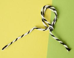 white-black rope on a green background twisted into a loop photo