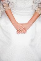 Bride hand on wedding dress with a nice manicure photo