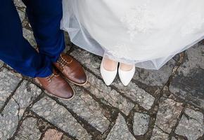 legs of bride and groom their bridal shoes photo