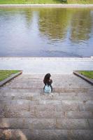 Beautiful girl sits and looks at the river Vilnius photo