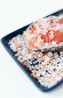 Fresh raw red salmon steak with large coarse pink salt prepared for baking on the grill lies on a blue plate. Healthy seafood food. Top view, place for an inscription. photo