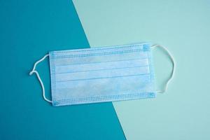 blue disposable medical mask on a blue background photo