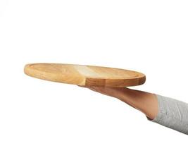 woman holding empty round wooden pizza board in hand photo