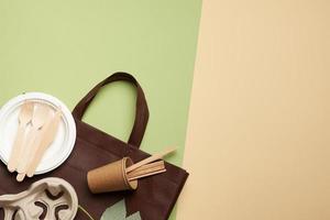 disposable paper utensils from brown craft paper and recycled materials on a green background, plastic rejection concept photo