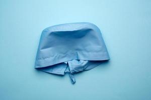 blue textile medical cap with ties for doctor, surgeon on blue background photo