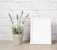 empty white wood frame and lavender pot on shelf, white brick wall photo