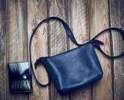 leather blue bag with long strap and wallet on wooden background photo