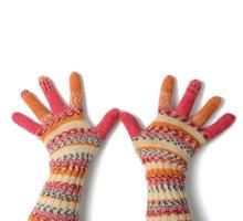 two female palms in knitted multi-colored mittens on a white background photo