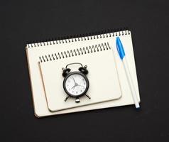 stack of spiral open notebooks with blank white sheets on a black background photo