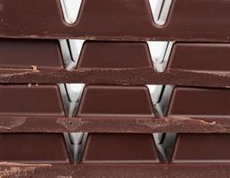 stack of pieces of black chocolate on a white background photo