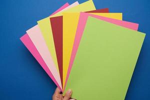 multicolored craft paper on blue background photo