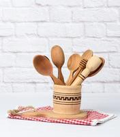 various spoons and kitchen wooden utensils in a bowl on a white table photo