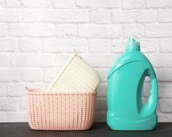 large plastic bottle with liquid detergent and a stack of baskets photo