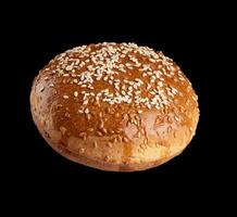 baked round bun with sesame seeds isolated on black background photo
