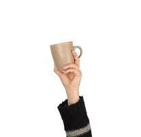 brown ceramic cup in a female hand on a white background photo
