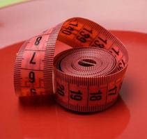 red measuring tape on a red background photo