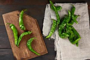 vainas de pimiento picante verde sobre una mesa de madera marrón foto