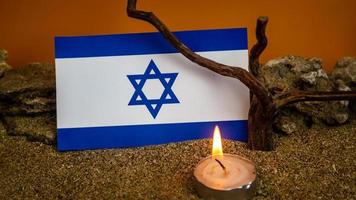 Israeli flag and candles burning in front of it, Holocaust memory day photo