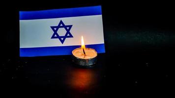 Israeli flag and candles burning in front of it, Holocaust memory day photo