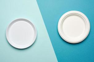 white plastic plates and white paper disposable plates on a blue background photo