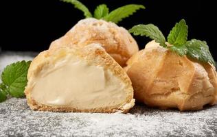 custard eclair cut in half and sprinkled with icing sugar photo