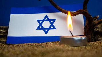 Israeli flag and candles burning in front of it, Holocaust memory day photo