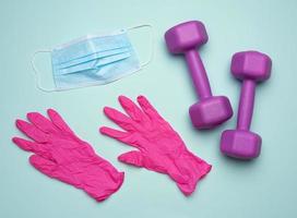 plastic dumbbells, a medical mask and pink latex gloves photo