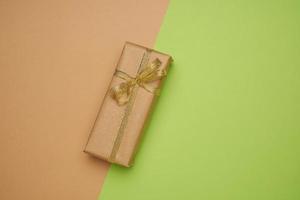 rectangular box wrapped in brown paper and tied with a silk ribbon with a bow photo